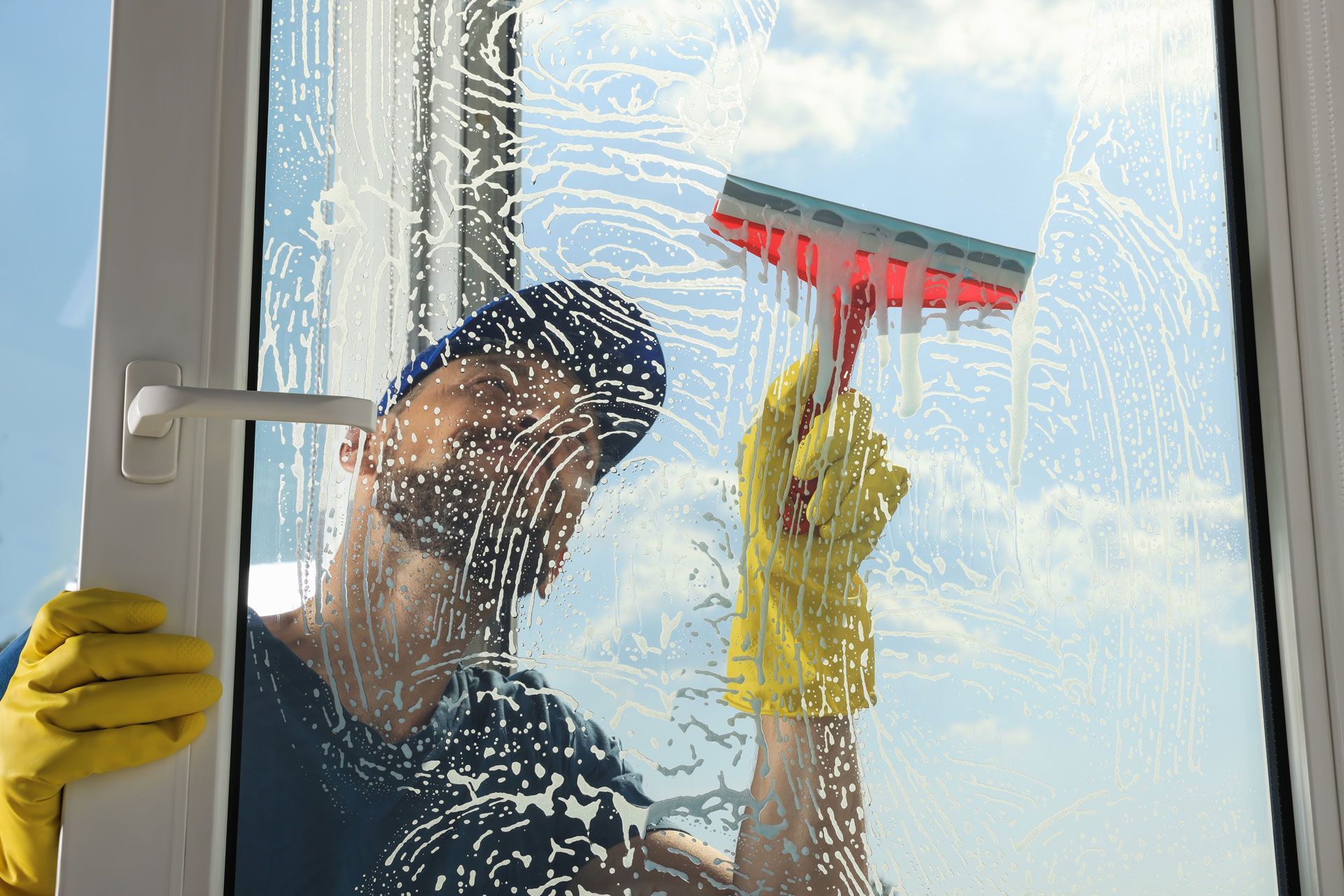 A man is cleaning a window with a squeegee.