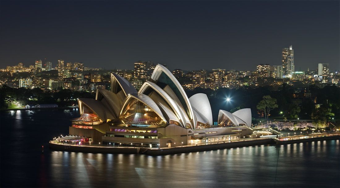The sydney opera house is lit up at night