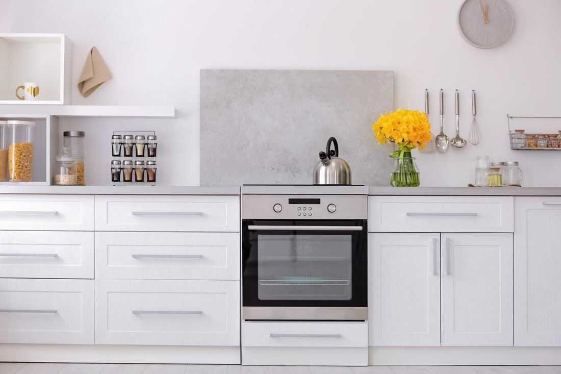 A Kitchen With White Cabinets, Oven and a Stove — A.S.A.P. Appliance Service & Sales in Wyong, NSW