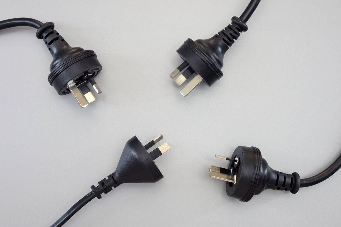 Four Black Electrical Plugs Are Laying on a White Surface — A.S.A.P. Appliance Service & Sales in Hamlyn Terrace, NSW