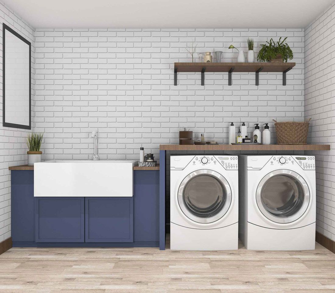 Laundry room with blue cabinets, white brick wall, and washer/dryer — A.S.A.P. Appliance Service & Sales in Hamlyn Terrace, NSW