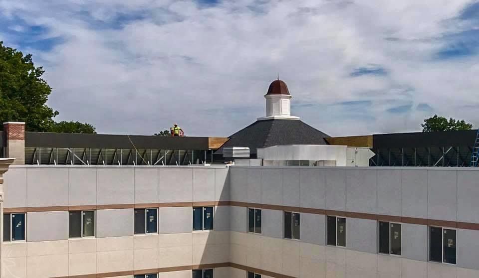 Building exterior with a cupola on the roof, under a cloudy sky.