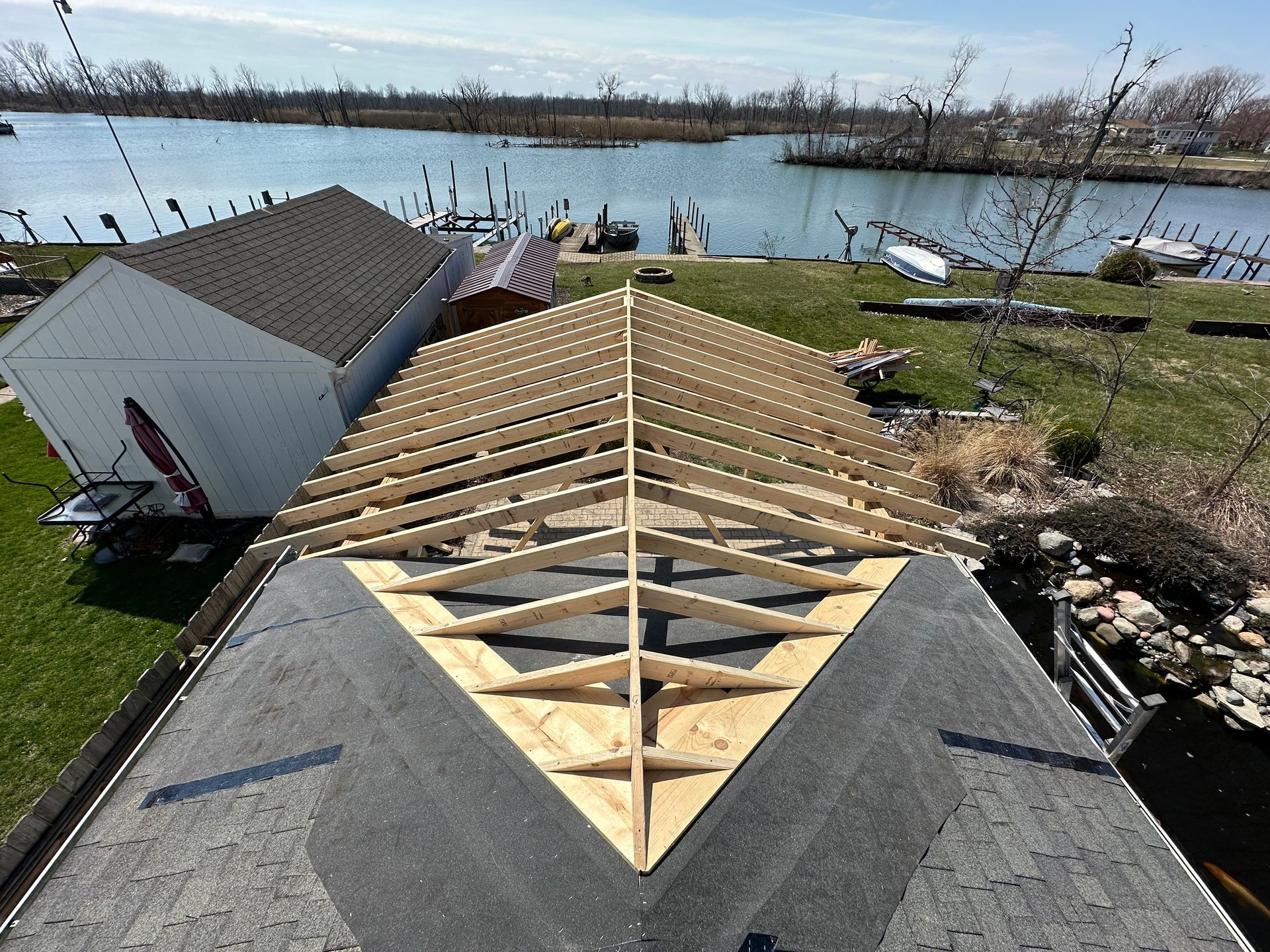 Roof framing construction with a water view.