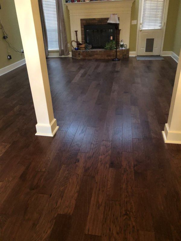 A living room with hardwood floors and a fireplace.