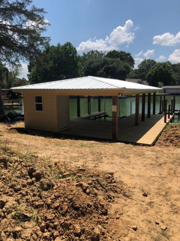 A house with a white roof is next to a body of water