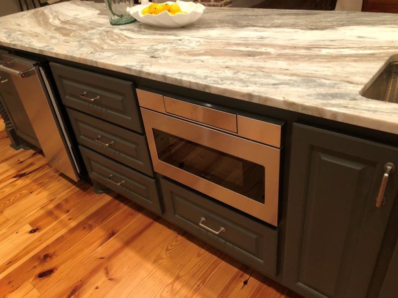 A kitchen with stainless steel appliances and wooden floors