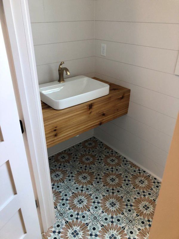 A bathroom with a sink and a wooden counter top.