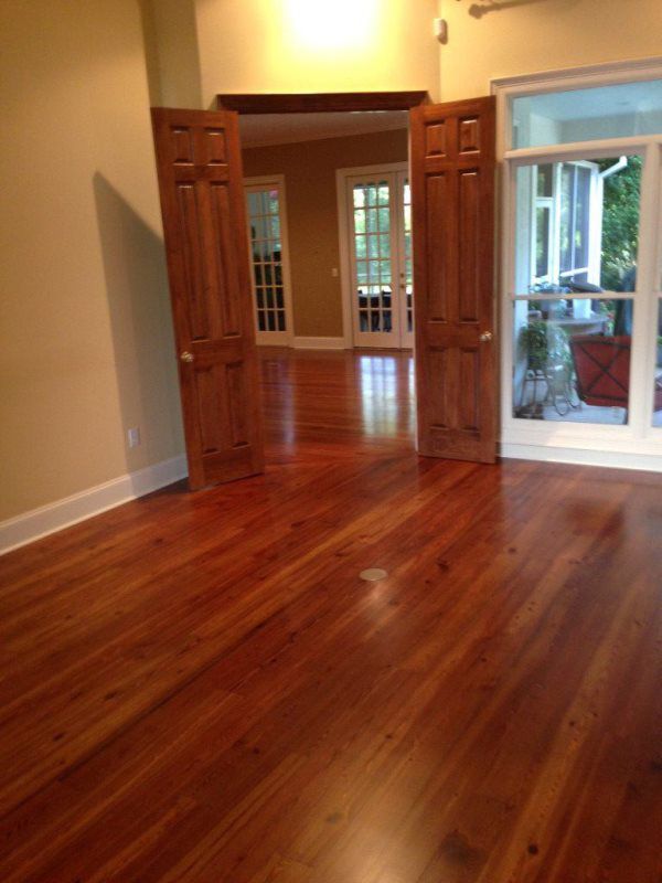 An empty room with hardwood floors and sliding glass doors
