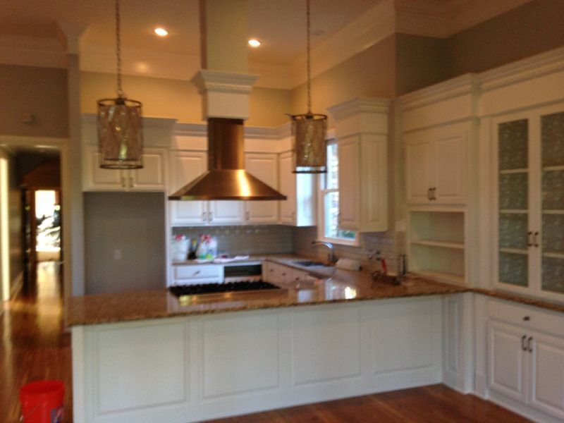 A kitchen with white cabinets and granite counter tops