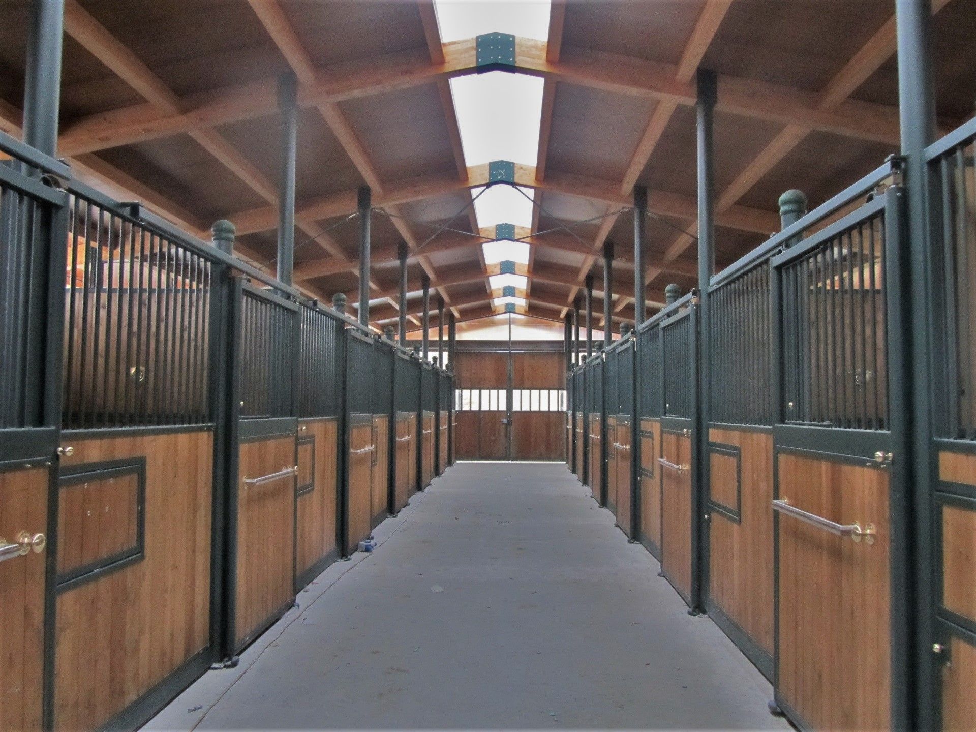 Interno scuderia zincata e verniciata con tamponamenti in legno larice e copertura con pannello coibentato effetto legno
