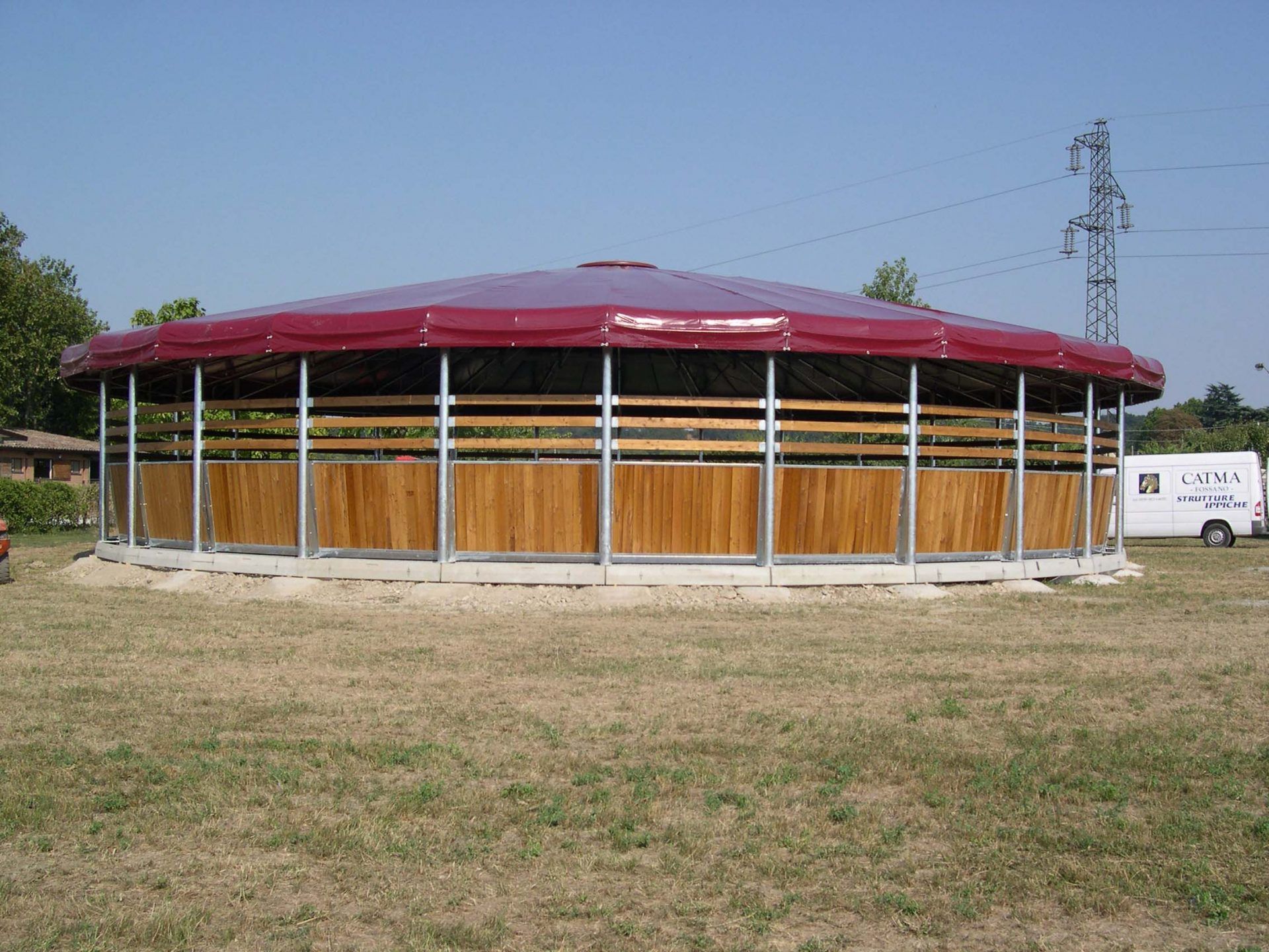 Tondino diametro 14 metri con tamponamento in legno larice e copertura telone rosso