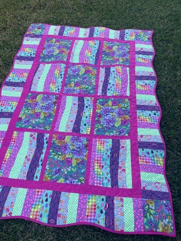 Colorful Quilt With Floral and Striped Patterns on Green Grass — Lyn-Jelle Crafts in Emu Park, QLD