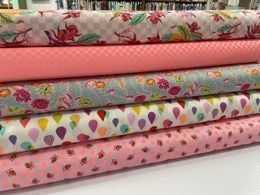 A Stack of Pink and White Fabrics With Balloons and Flowers on Them — Lyn-Jelle Crafts in Emu Park, QLD