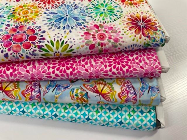A Stack of Fabrics With Flowers and Butterflies on Them — Lyn-Jelle Crafts in Emu Park, QLD