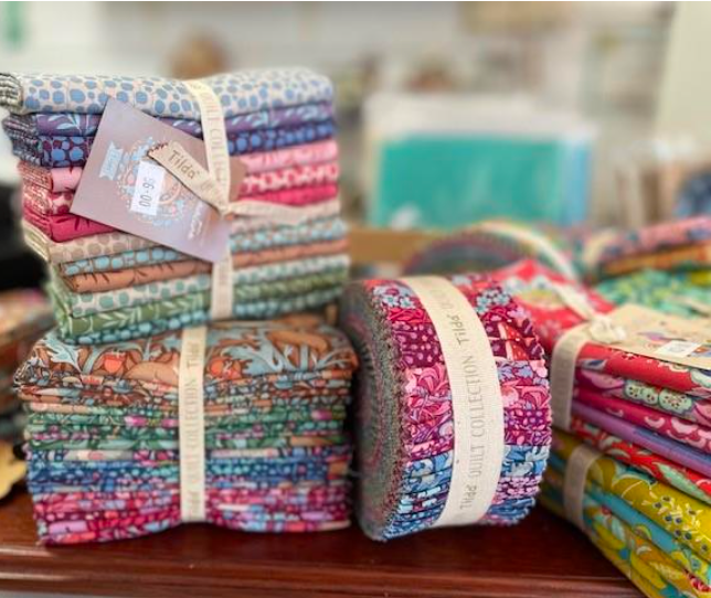 A Bunch of Colorful Fabrics Are Stacked on Top of Each Other on a Table — Lyn-Jelle Crafts in Emu Park, QLD