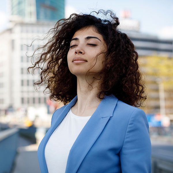 business woman standing outside feeling relaxed