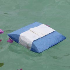 A blue and white pillow is floating in the water.