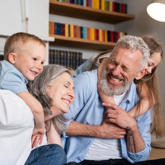 A man and woman are sitting on a couch with two children.