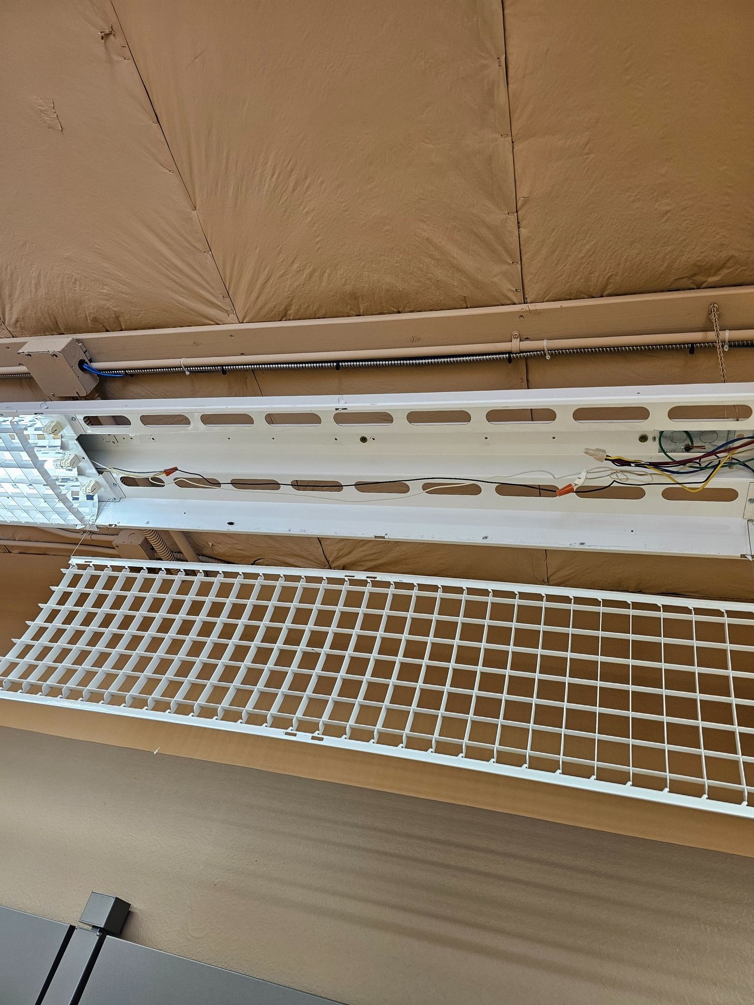 A white light fixture is sitting on top of a wooden table.