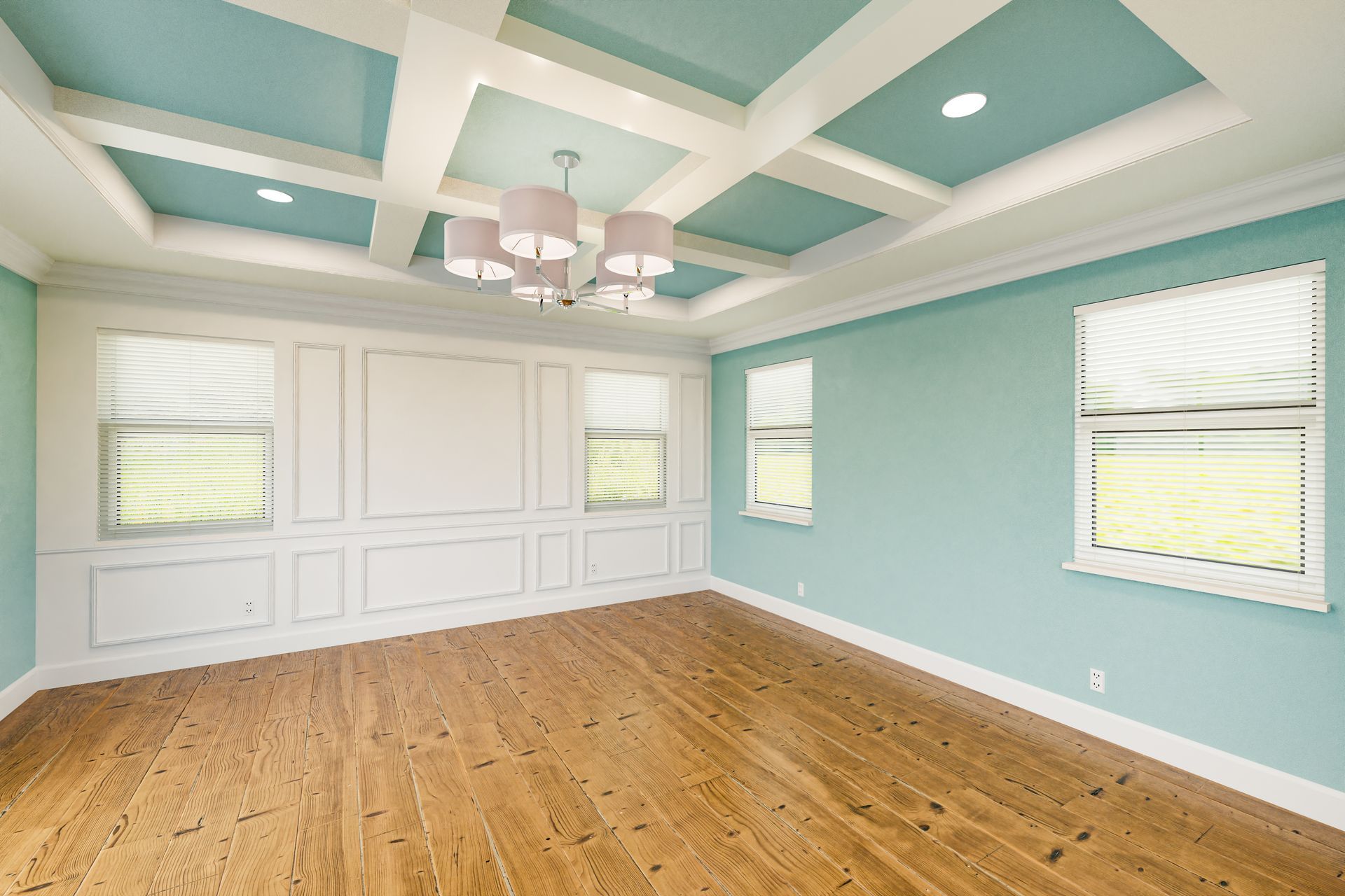 An empty room with blue walls and hardwood floors and a coffered ceiling.