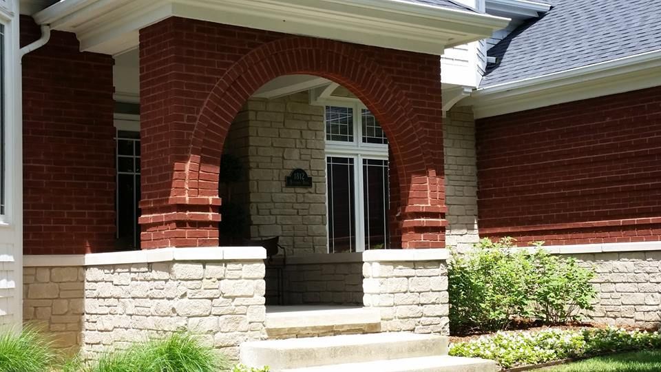 A red brick house with a stone porch and steps