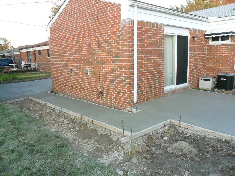 A brick house with a concrete walkway in front of it