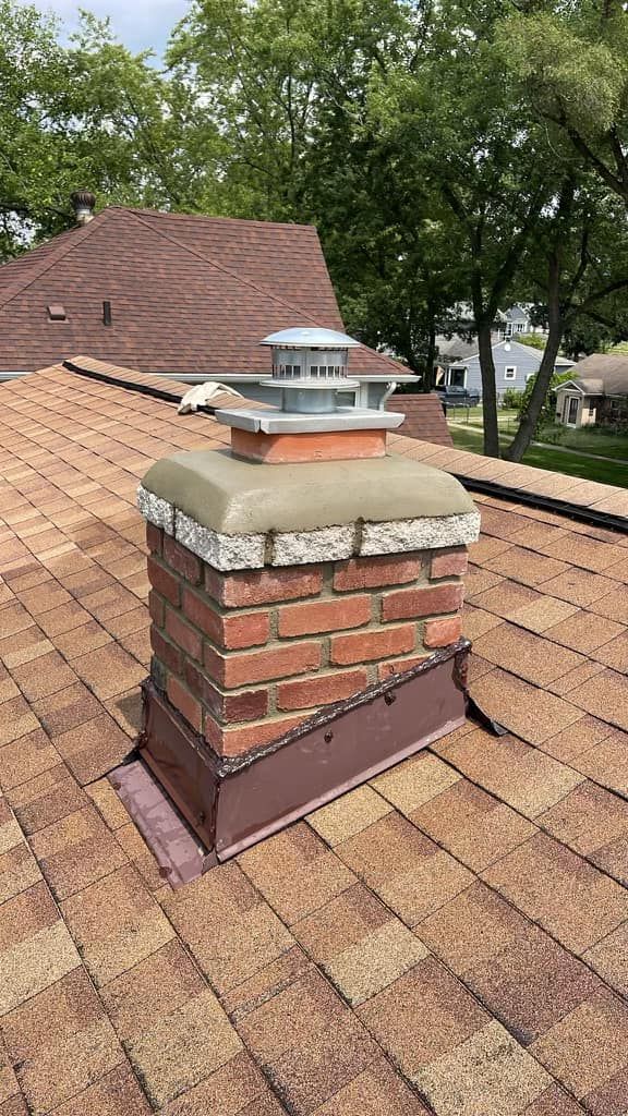 A brick chimney is sitting on top of a roof.