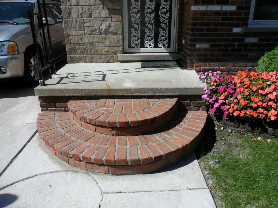 A car is parked in front of a brick house
