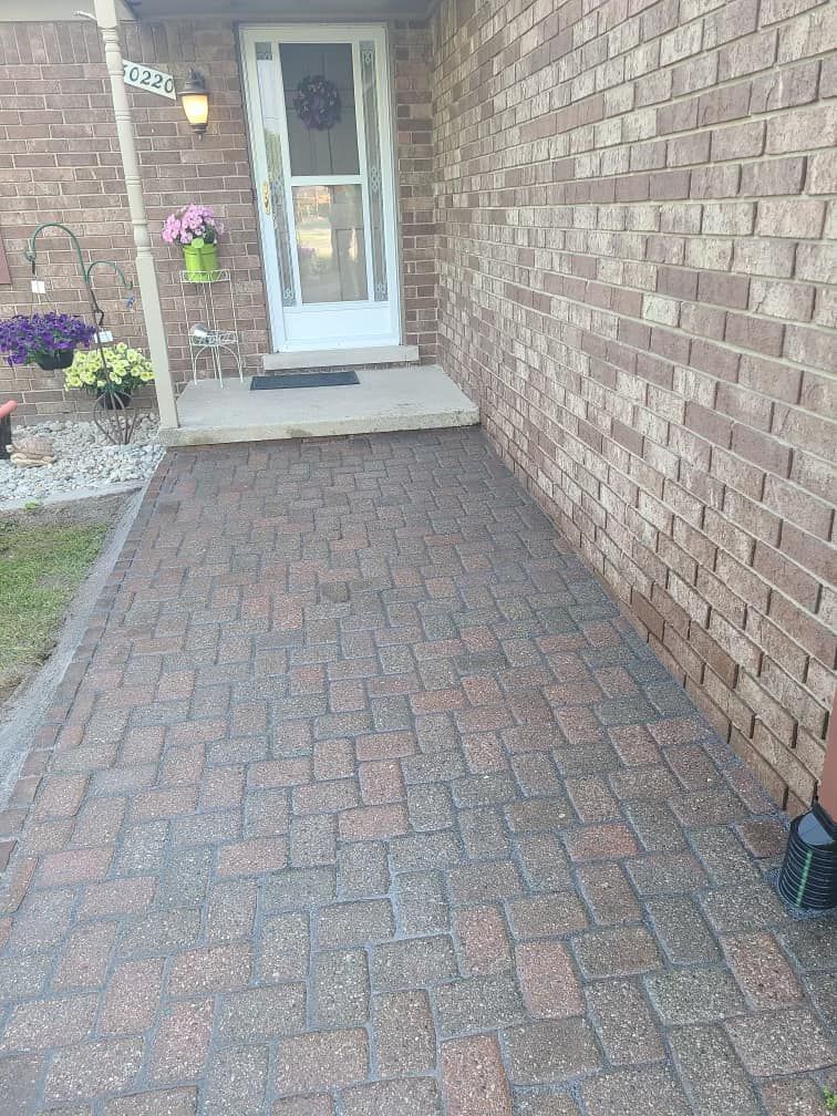 A brick walkway leading to the front door of a house.