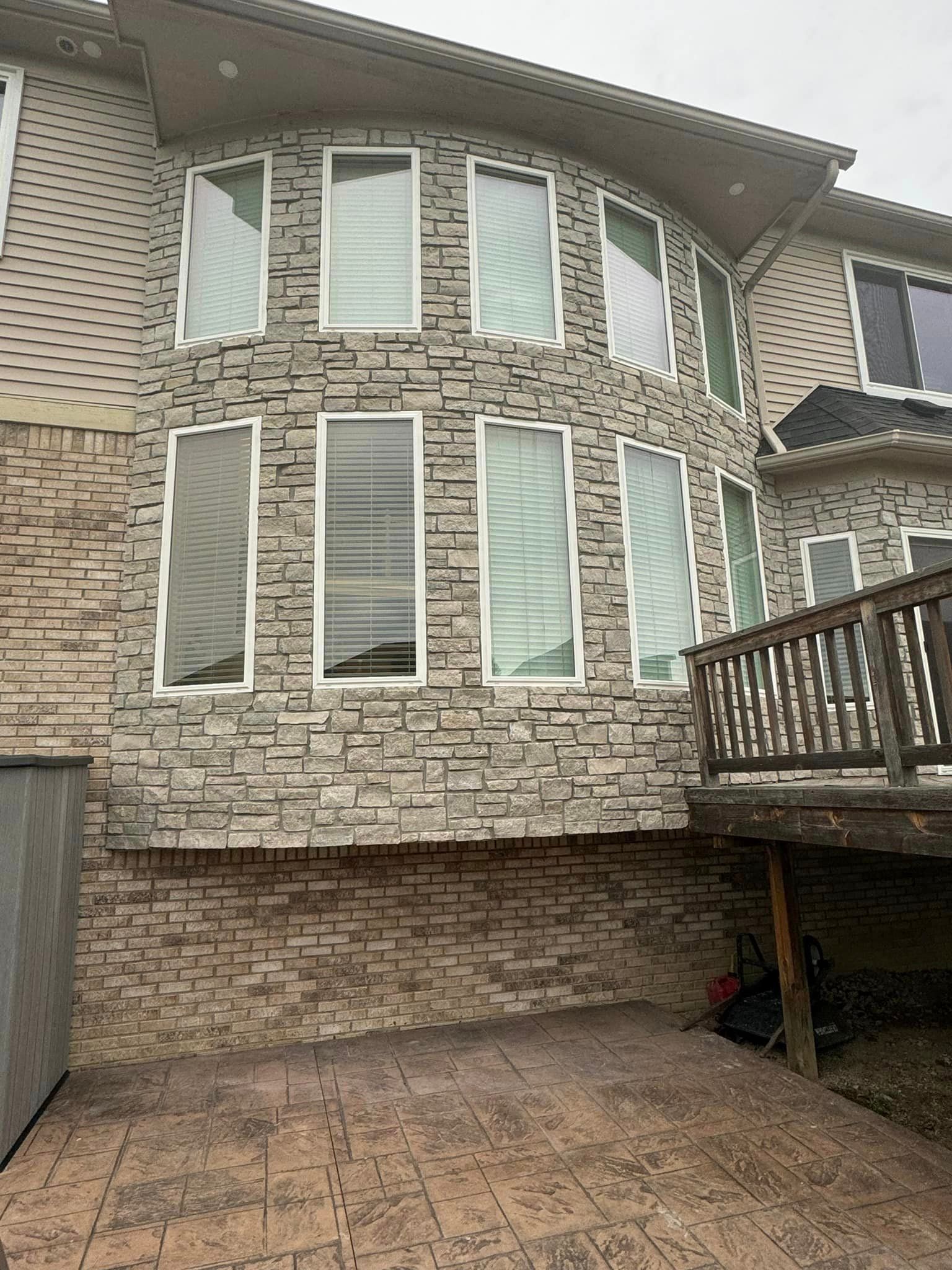 A large brick house with a lot of windows and a deck.