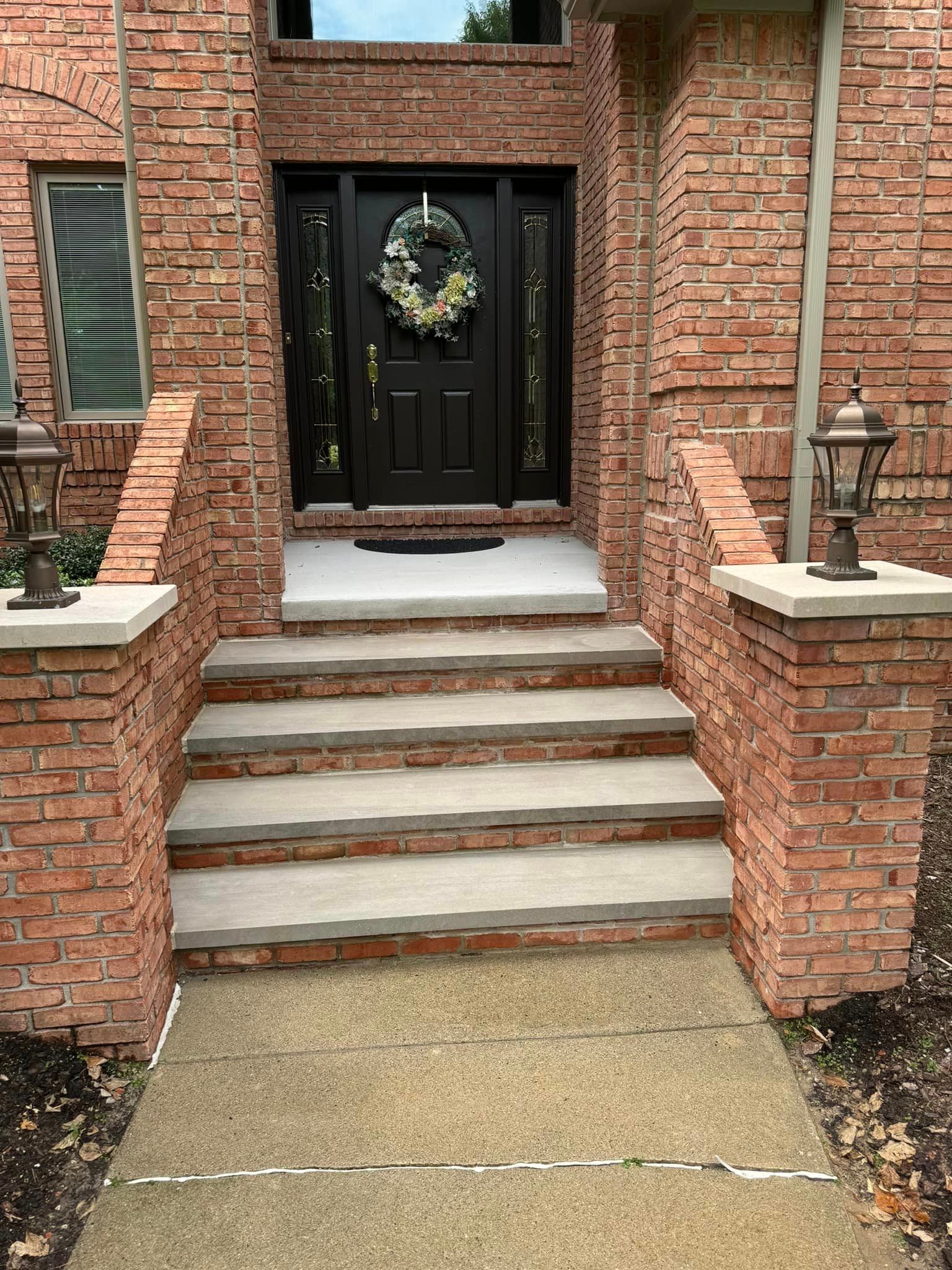 The front door of a brick house with a wreath on it.