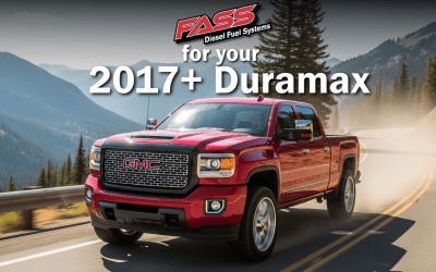 A red gmc truck is driving down a mountain road.
