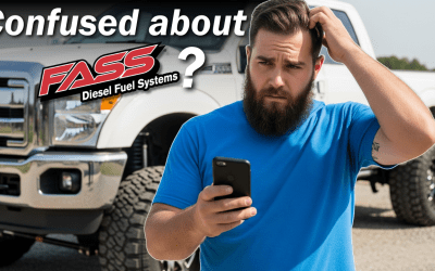 A man with a beard is holding a cell phone in front of a truck.