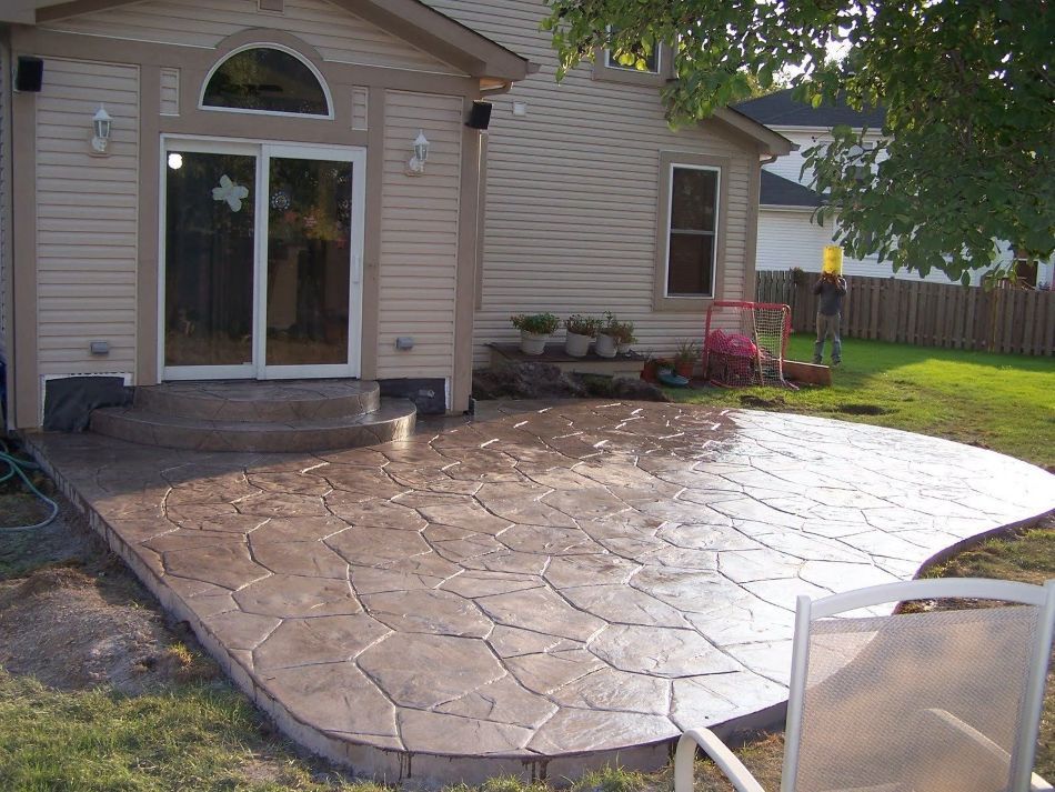 A patio in front of a house with sliding glass doors