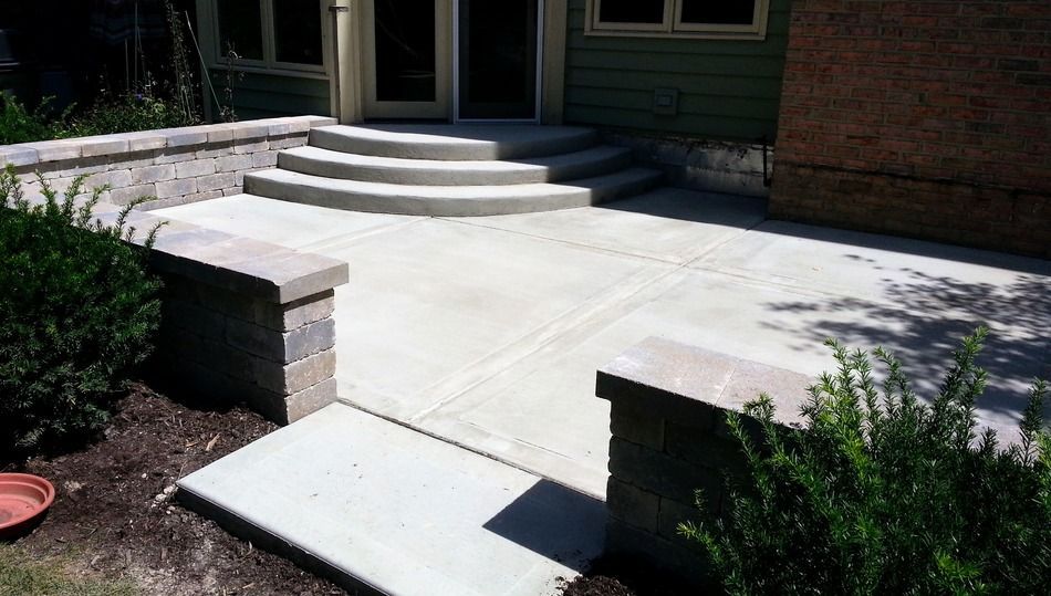 A concrete walkway leading to the front door of a house.