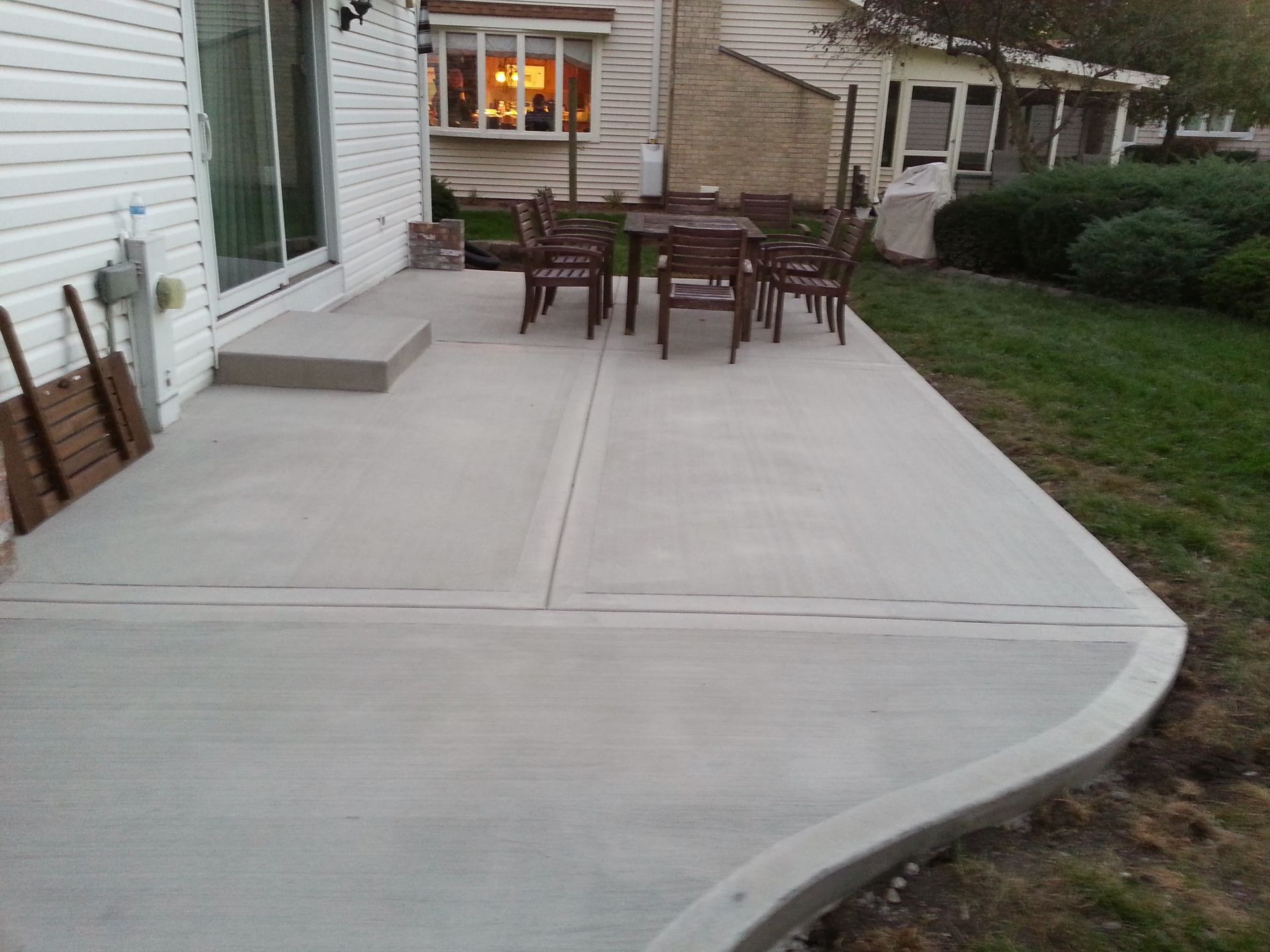 A patio with a table and chairs in front of a house.