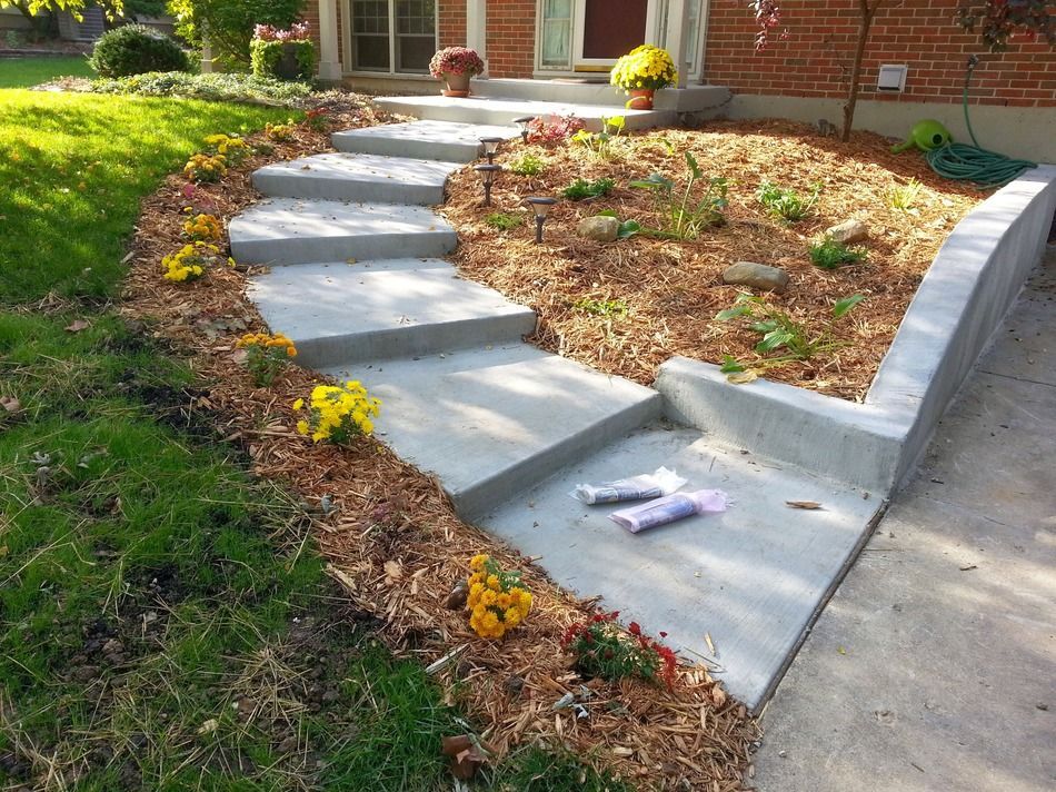 A concrete walkway leading to a brick house