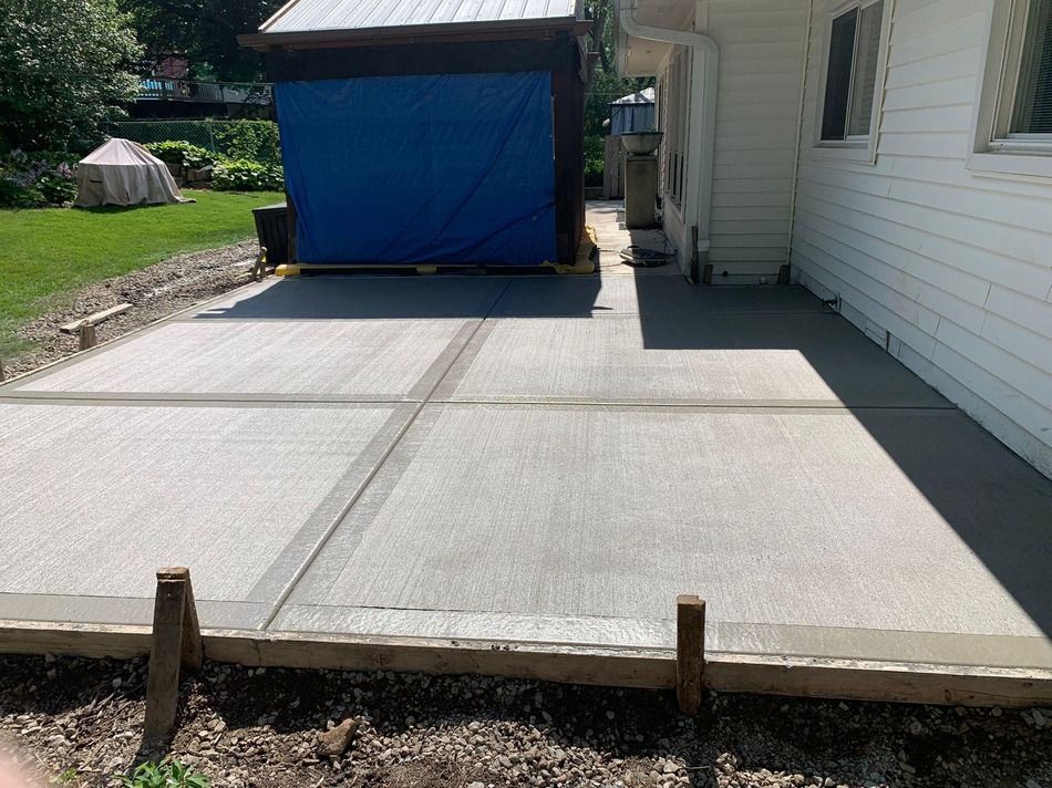 A concrete driveway is being built in front of a house.