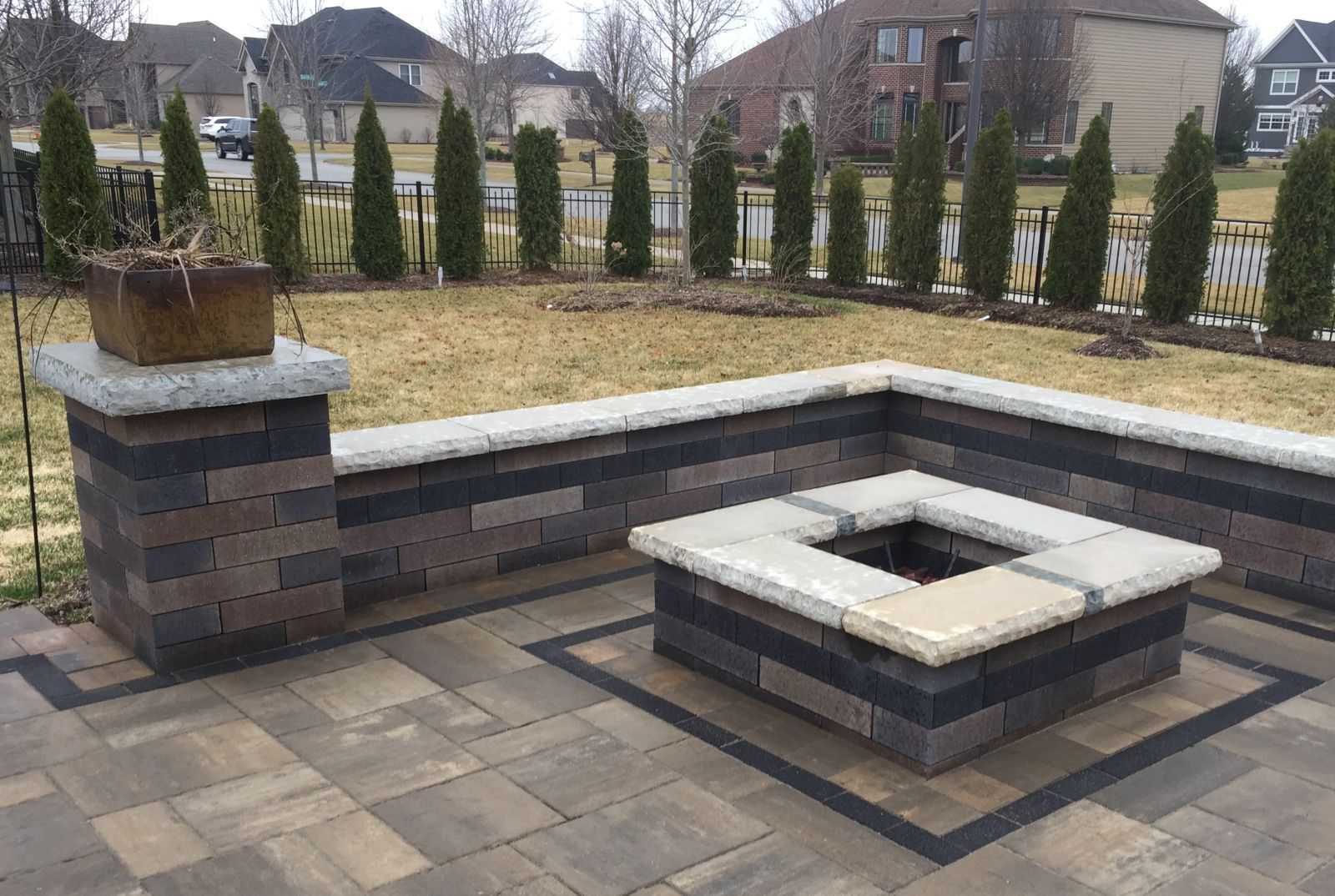 Stamped concrete patio with a stone-like pattern, in brown and gray hues, leading to a pathway and a building.
