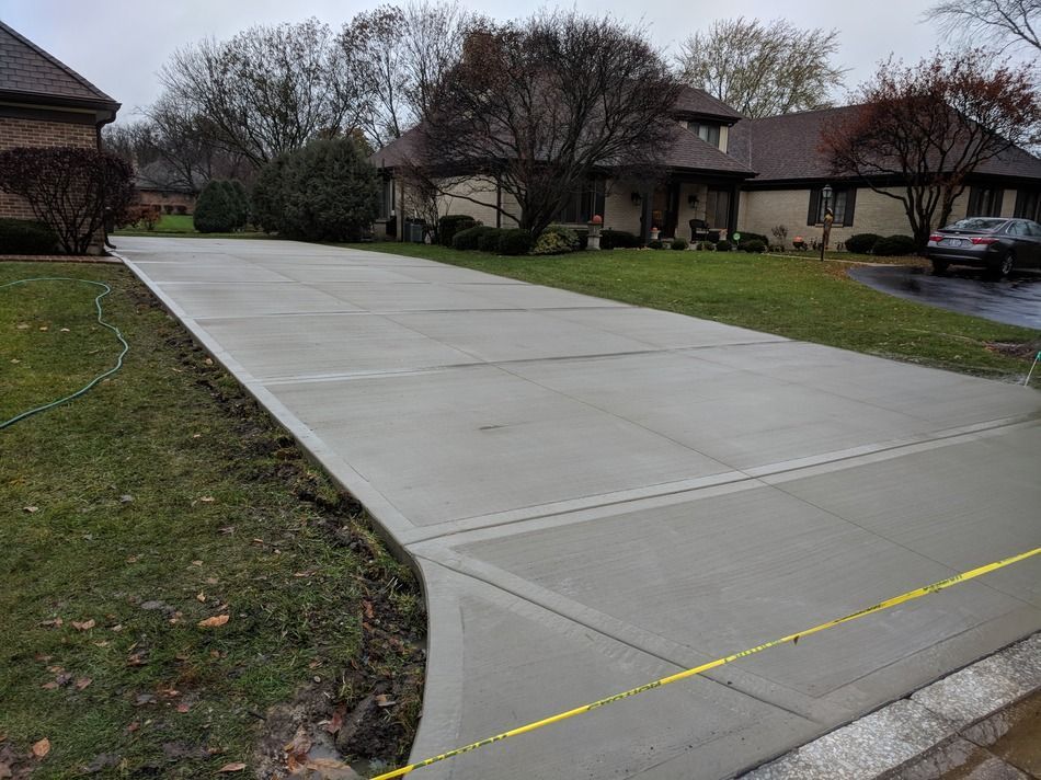 A concrete driveway is being built in front of a house.