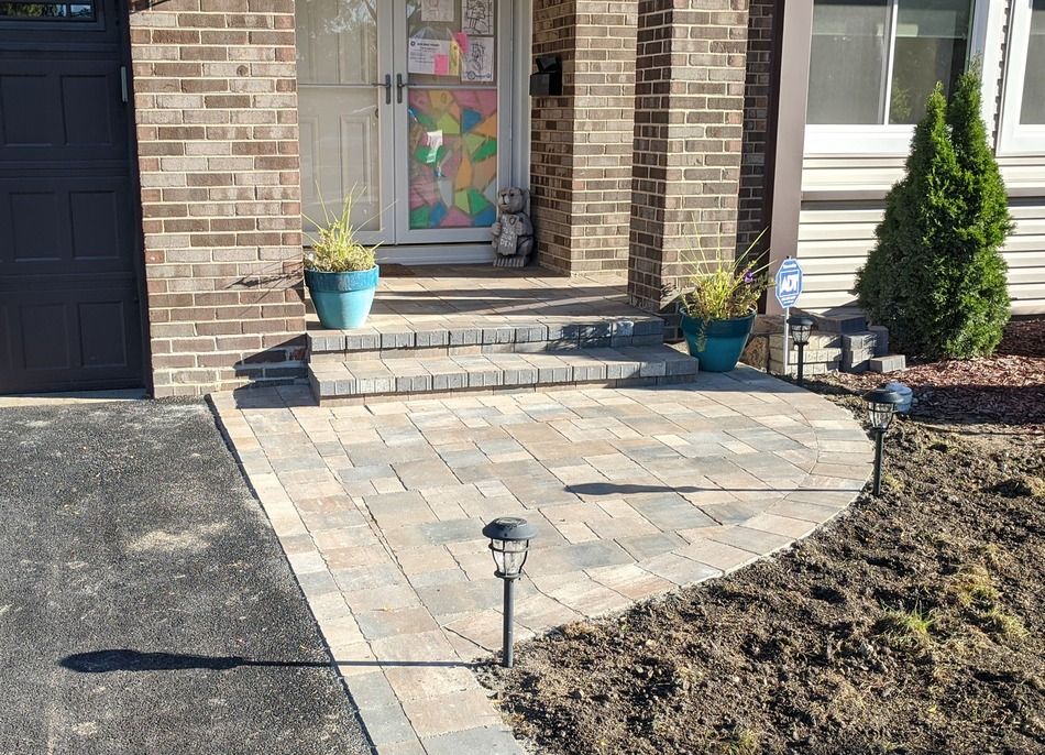 A brick house with a walkway leading to the front door.