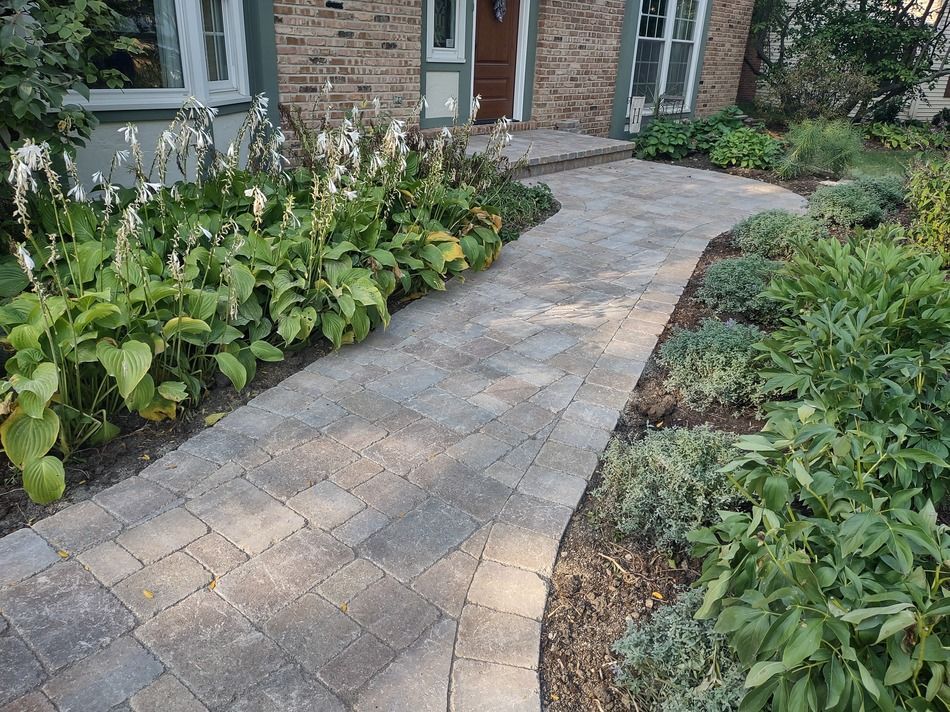 A brick walkway leading to a brick house