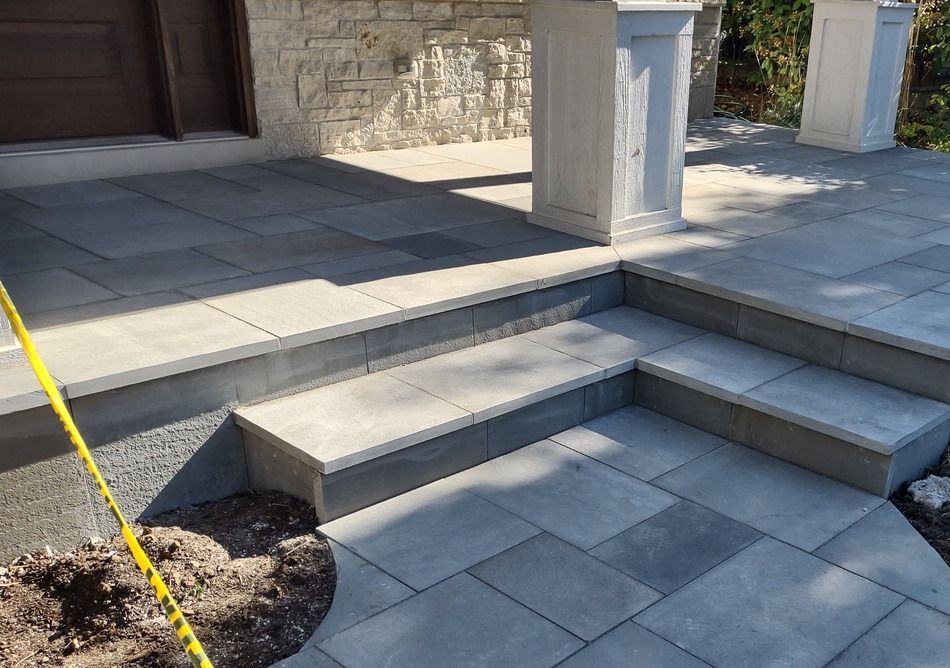 A concrete porch with steps leading up to a garage door.