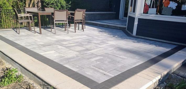 Brick Patio with table, chairs, and dark border. Gazebo in background.