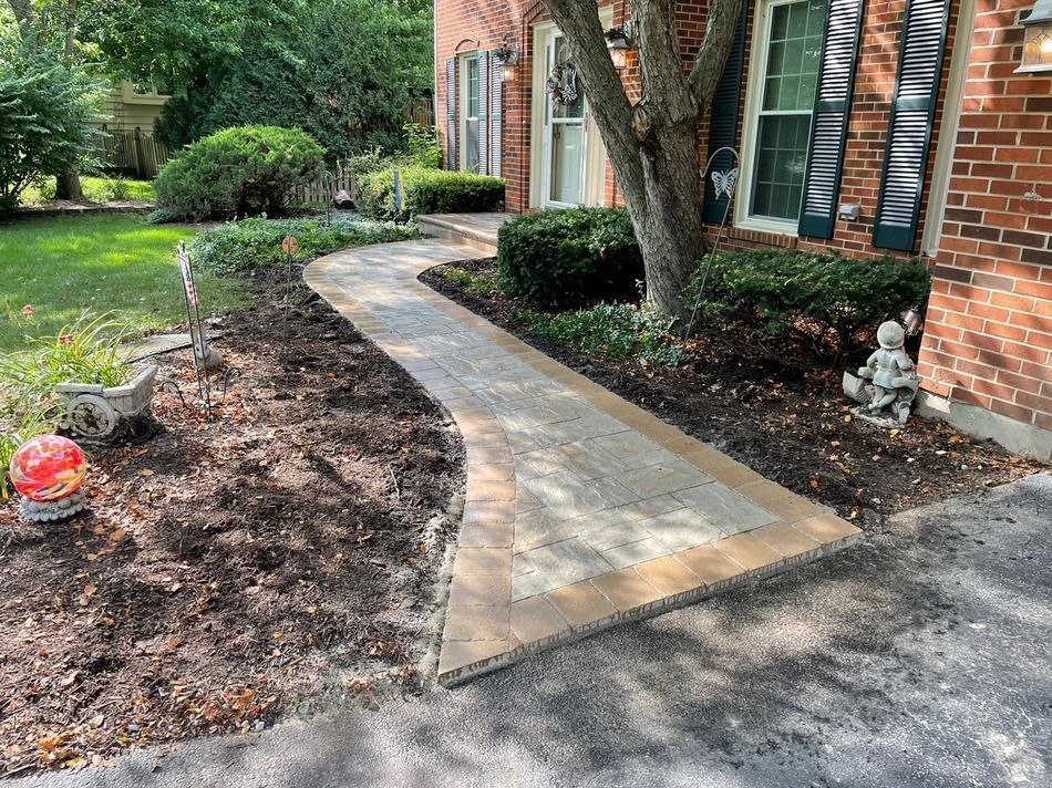 A walkway is being built in front of a brick house.