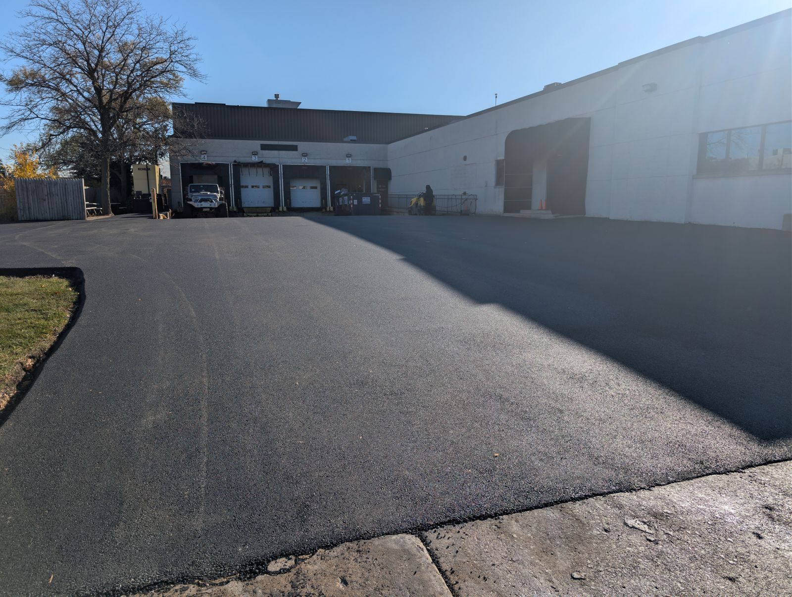Stamped concrete patio with a stone-like pattern, in brown and gray hues, leading to a pathway and a building.