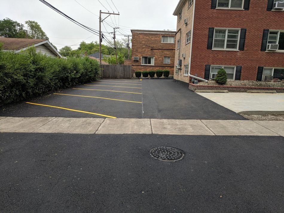 A parking lot with a brick building in the background