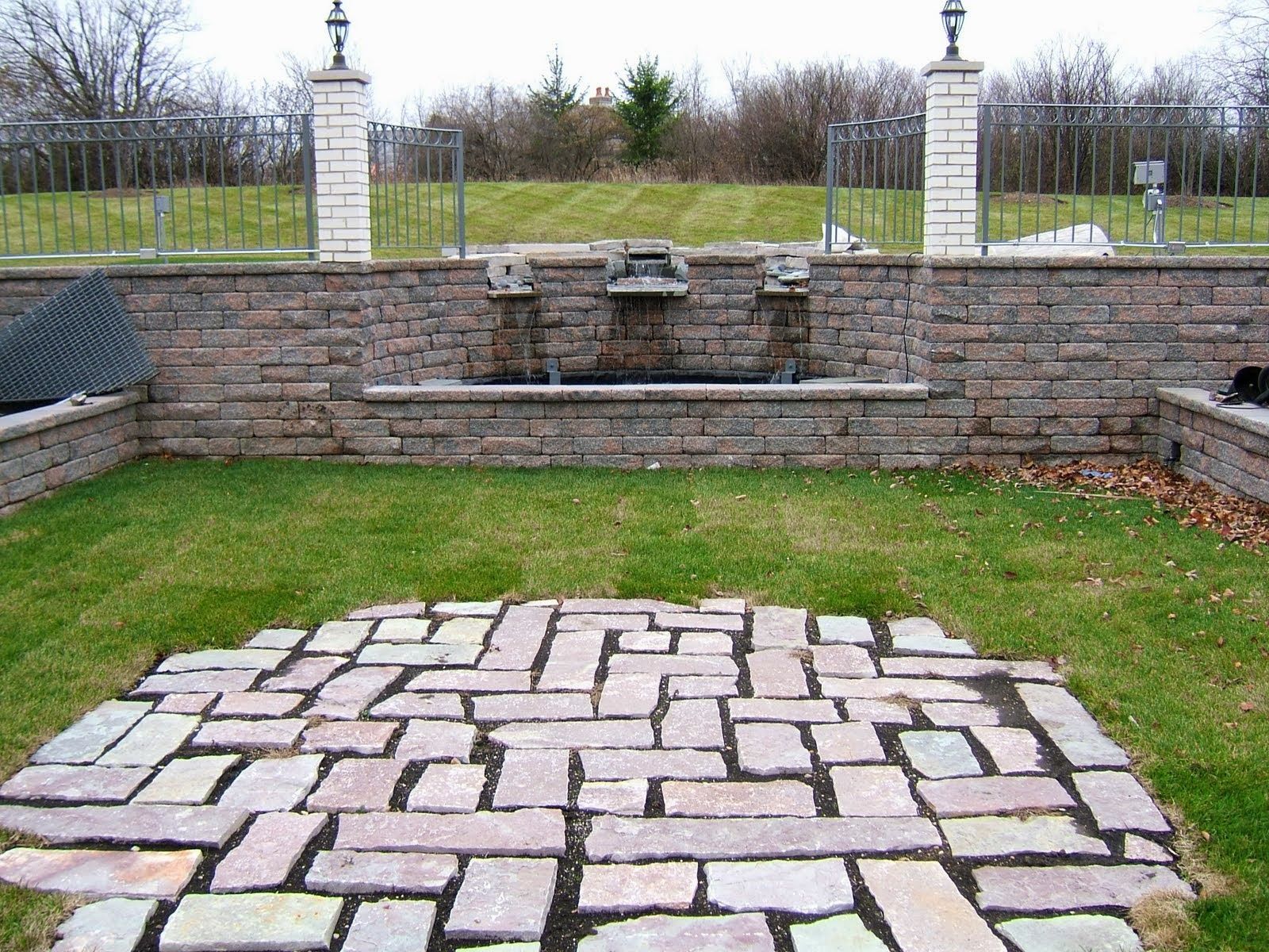 A brick walkway with a fountain in the background