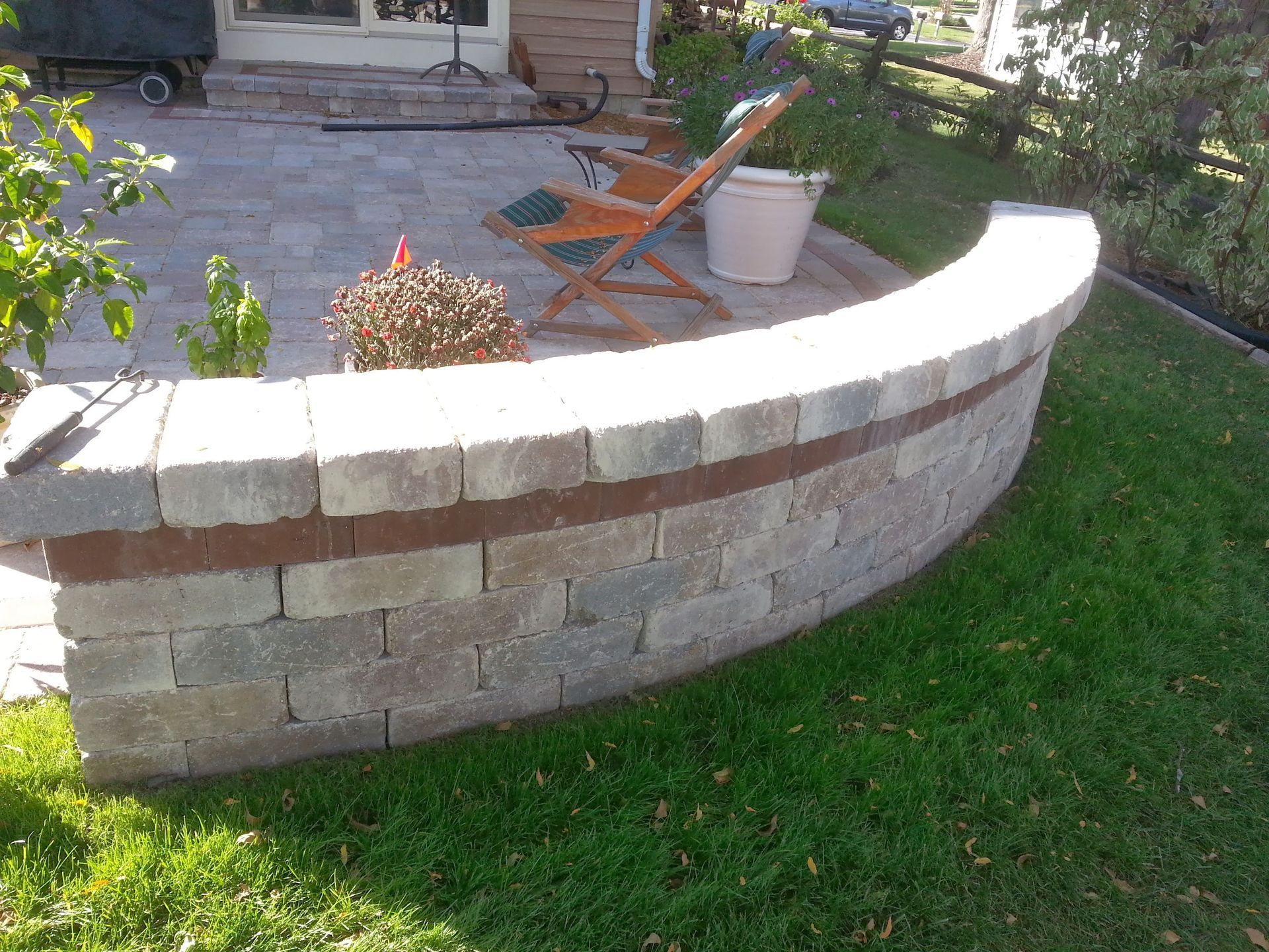 A brick wall with a chair and potted plants on it