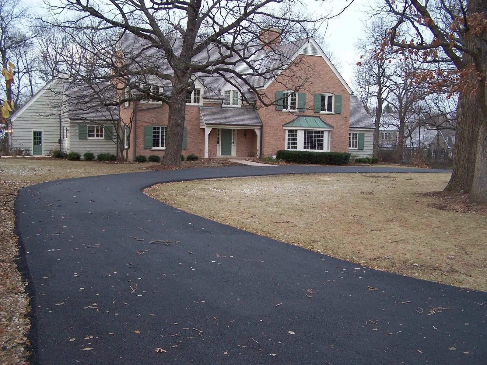 A brick driveway leading to a brick house